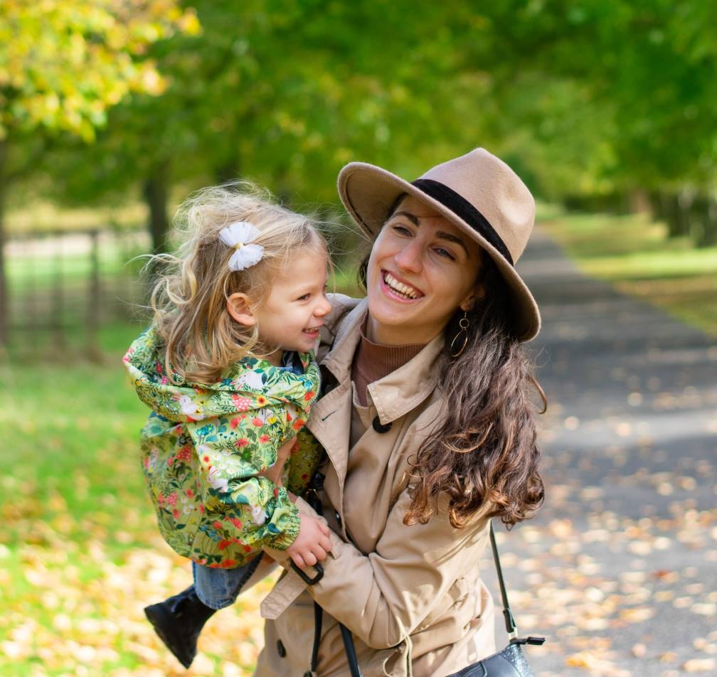 Woman with hat, holding her daughter in Bushy park, family photoshoot